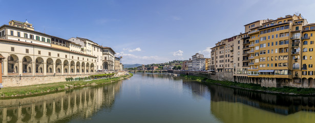 Beautiful panoramic view of the Lungarni and the Vasari corridor from the Ponte Vecchio in the historic center of Florence, Italy, on a sunny day