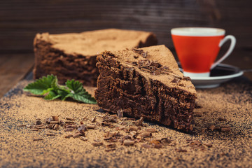 chocolate cake with Candies and cup of coffee,Chocolate cake with a cut piece and blade on gray background,closeup,Dark chocolate cake,vegan chocolate cake,Tasty chocolate cake on wooden background