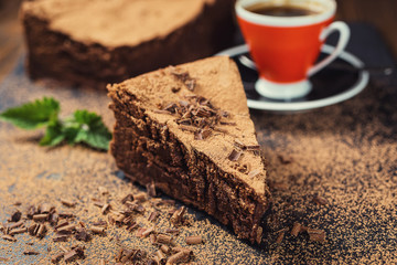 chocolate cake with Candies and cup of coffee,Chocolate cake with a cut piece and blade on gray background,closeup,Dark chocolate cake,vegan chocolate cake,Tasty chocolate cake on wooden background