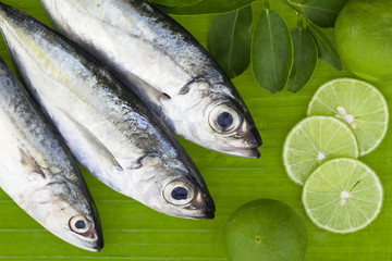 fish with lemon and leafs on banana leaves background,concept cooking background.