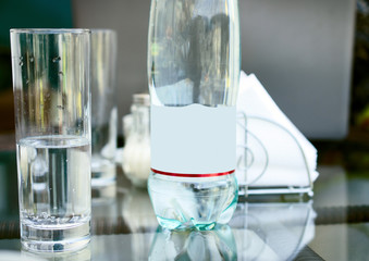 Bottle with mineral water and glass.