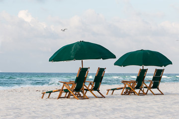 Beach chairs and umbrellas on beach with waves and sand. - 145479913