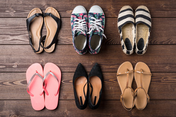 Collection of women's shoes on wooden background