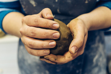 Girl potter kneads soft clay