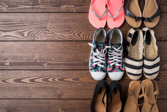 Collection of women's shoes on wooden background