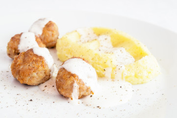turkey meatballs and mashed potato under bechamel sauce sprinkled with black pepper