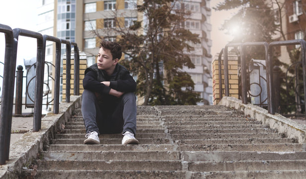 Sad young man sitting on the stairs