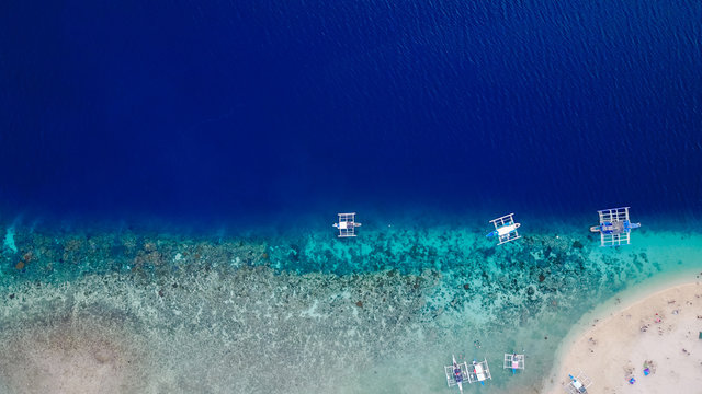 Aerial view of sandy beach with tourists swimming in beautiful clear sea water - Boost up color Processing.
