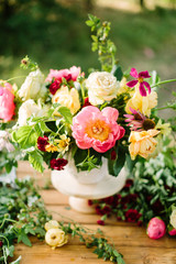 bouquet, holiday flower, gifts and floral arrangement concept - white vase with a beautiful bouquet on a wooden table, decorative arrangement of yellow and white roses, pink peons, daisies, carnations