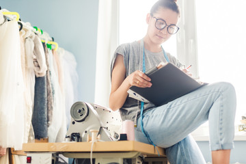 Dressmaker designing clothes pattern on paper