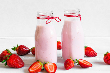 Strawberry smoothie or milkshake in a bottle with fresh berries