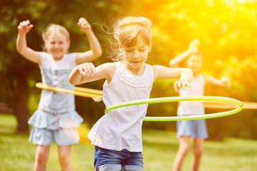 Kinder spielen im Sommer mit Reifen