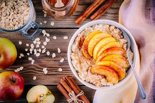 Healthy breakfast: oatmeal bowl with caramelized apples, cinnamon and honey