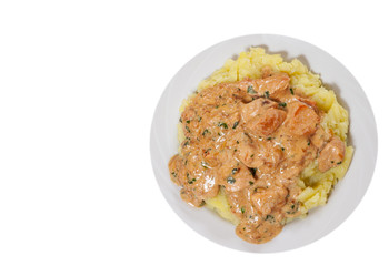 chicken breast in a creamy sauce with mashed potatoes. top view. isolated on white