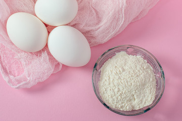 White eggs and white flour, from above. Ingredients for cooking.
