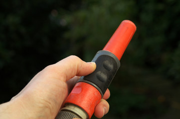 Hand on garden hose nozzle