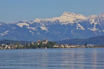 Medieval castle in Rapperswil. Lake Zurichsee and snow capped mountain Grosser Speer.