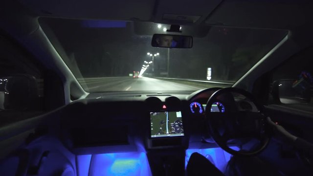 The man drive a car on the night highway. inside view. left side traffic, real time capture