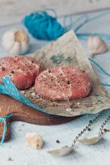 Organic raw ground beef wrapped in strips of bacon.