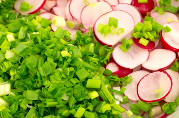 Background of freshly cut radishes and onions