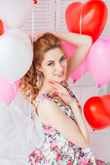 Girl in romantic dress with balloons in the shape of a heart