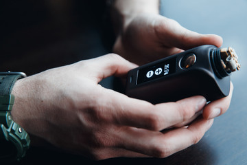 male master installs a coil. Spiral for electronic evaporator and cigarette. Vape, vaping. Firing a coil.