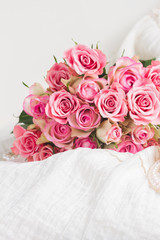 Female dress and jewellery with freah roses bouquet on chair, vertical shot