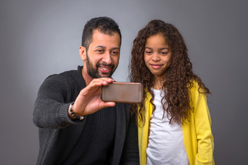 Black father taking selfies with his daughter 