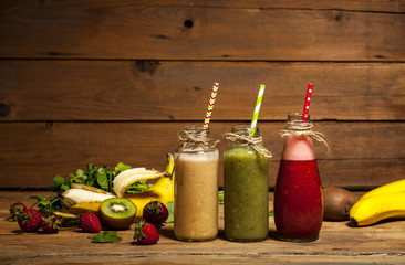 Fototapeta na wymiar Assortment of fruit and vegetable smoothies in glass bottles with straws