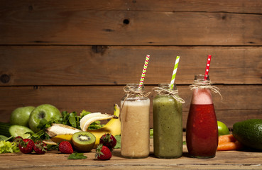 Assortment of fruit and vegetable smoothies in glass bottles with straws