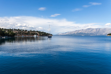 Naklejka premium Sailing boat in the beautiful blue lagoon. Yachting in Ionian Sea, Lefkada Island, Greece