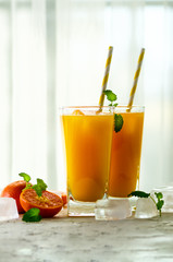 Fresh orange juice, mint and ice on white background, top view, copy space. Summer cocktail, drink