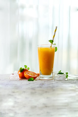 Fresh orange juice, mint and ice on white background, top view, copy space. Summer cocktail, drink