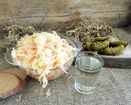 Cabbage fermented, pickles and vodka are on a table. Traditional national Russian drink and snack