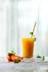 Orange juice with ice and tangerines on white background. Free space for your text. Copyspace. Cold beverage for hot summer day.