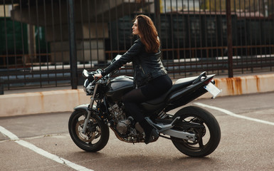 Fototapeta na wymiar Cute young brunette woman and motorcycle