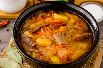 Shchi - traditional russian cabbage soup on wooden table.