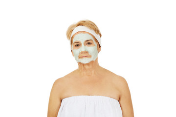 Relaxed elderly woman in facial mask