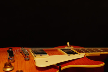 Solid body electric guitar closeup on the black background, with plenty of copy space. Selective...