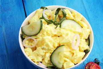 A delicious homemade creamy potato salad on a picnic table.