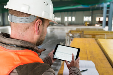 Construction supervisor with digital tablet on site