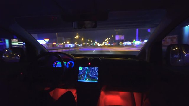 The man drive a car on the city road. inside view. evening night time, real time capture