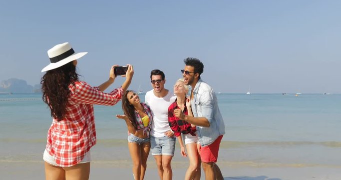 Girl Taking Photo Of People Group On Beach On Cell Smart Phone Happy Cheerful Man And Woman Posing Tourists On Vacation Slow Motion 60