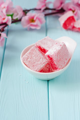 Rose flavored rahat lokum Turkish delight on wooden background. Selective focus. Ramadan food