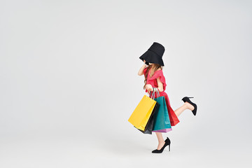 Busy girl in oversized high heels and with shoppers bags