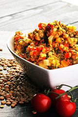 Lentil with carrot and pumpkin ragout in a wooden bowl on a wood