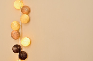 Shining cotton light balls in soft beige, brown and white colors in home interior for background. Copy space.