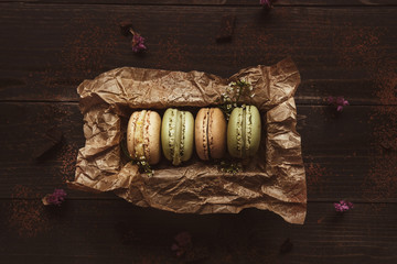 Delicious macaroons in gift box on the wooden table, top view
