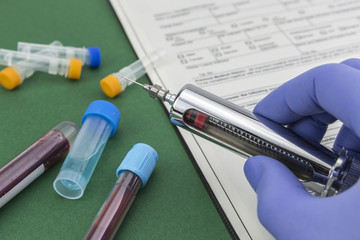 Scientist with blue latex gloves holds syringe special in laboratory for analysis