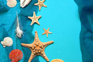 Marine blue background with seashells and starfish in fishing nets with place for your text